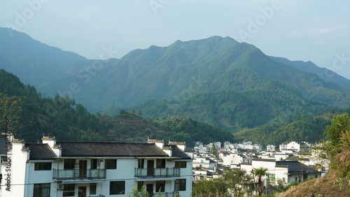 The beautiful traditional Chinese village view with the classical architecture and fresh green trees as background © Bo