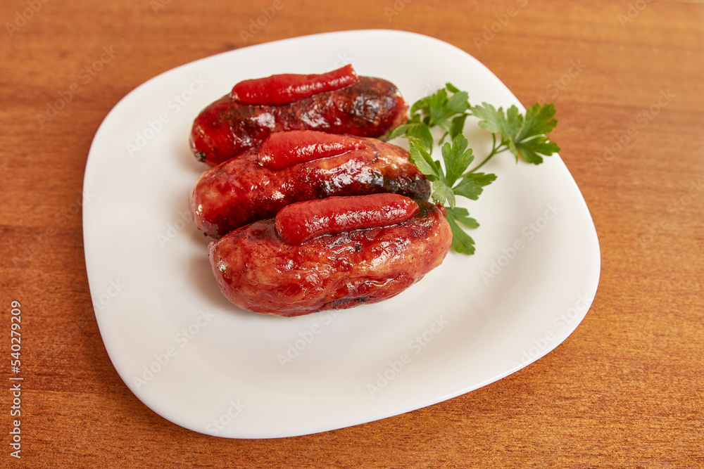 Fried sausages with ketchup on a white plate. Fried sausages with ketchup on a white plate.