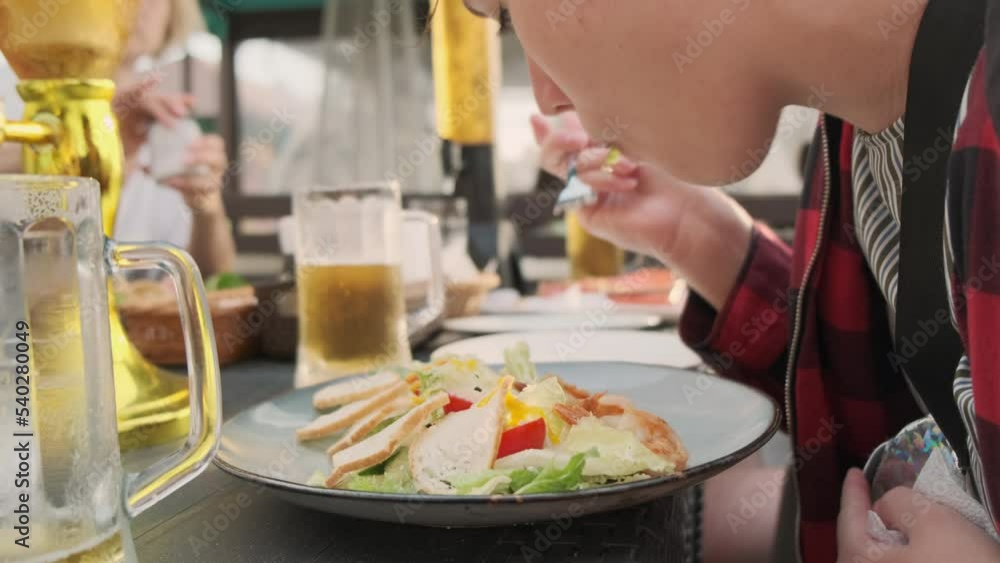 Young woman eating delicious side dish in street cafe. Young woman eating delicious side dish in street cafe.