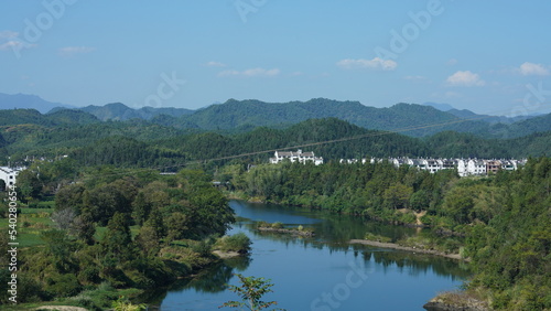 The beautiful traditional Chinese village view with the classical architecture and fresh green trees as background