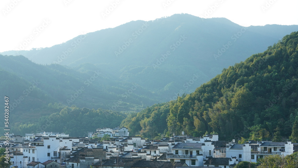 Fototapeta premium The beautiful traditional Chinese village view with the classical architecture and fresh green trees as background