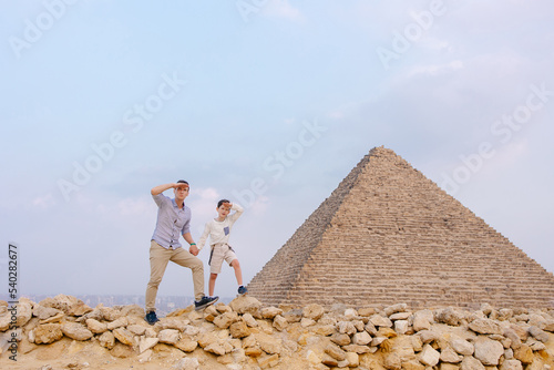 Father and child together in front of the pyramids in Cairo. Tourist trip to Egypt. Excursion to the wonder of the world. Incredible emotions of happiness and delight. A chidhood dream. Family in Giza photo