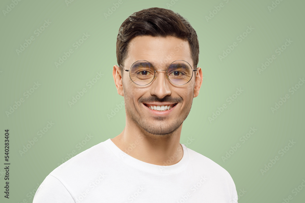Headshot of confident smiling guy wearing white t-shirt and round glasses on green background Headshot of confident smiling guy wearing white t-shirt and round glasses on green background