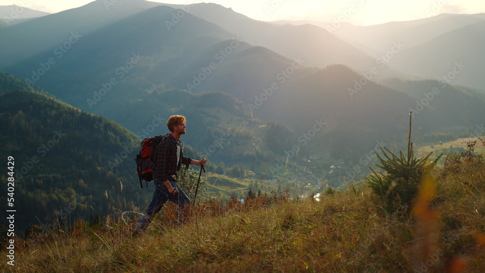 Fototapeta premium Strong man climb mountains hill nature. Walking tourist enjoy hike on vacation.