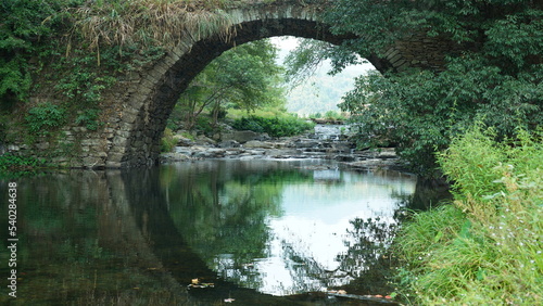The old arched stone bridge view located in the countryside of the China