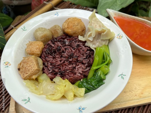 Brown rices, meat ball and yulk with red sauce photo