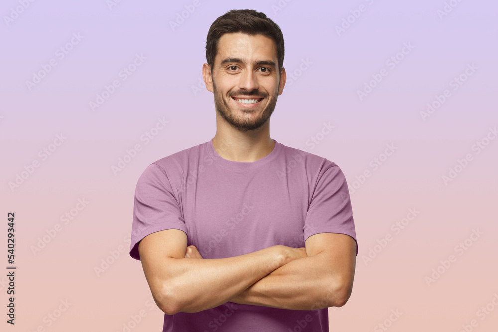 Fototapeta premium Indoor portrait of european caucasian man on purple background in t-shirt with crossed arms