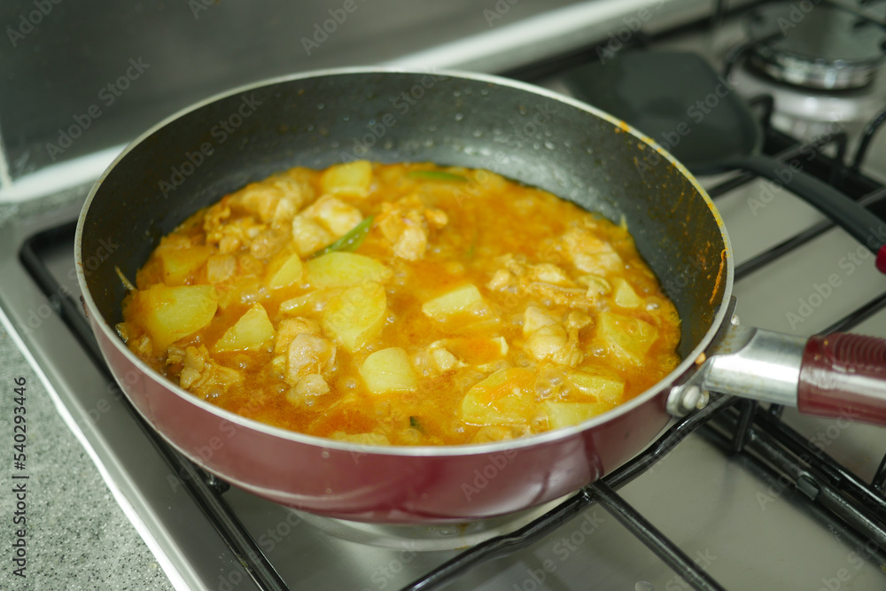 cooking chicken curry in a cooking pan cooking chicken curry in a cooking pan
