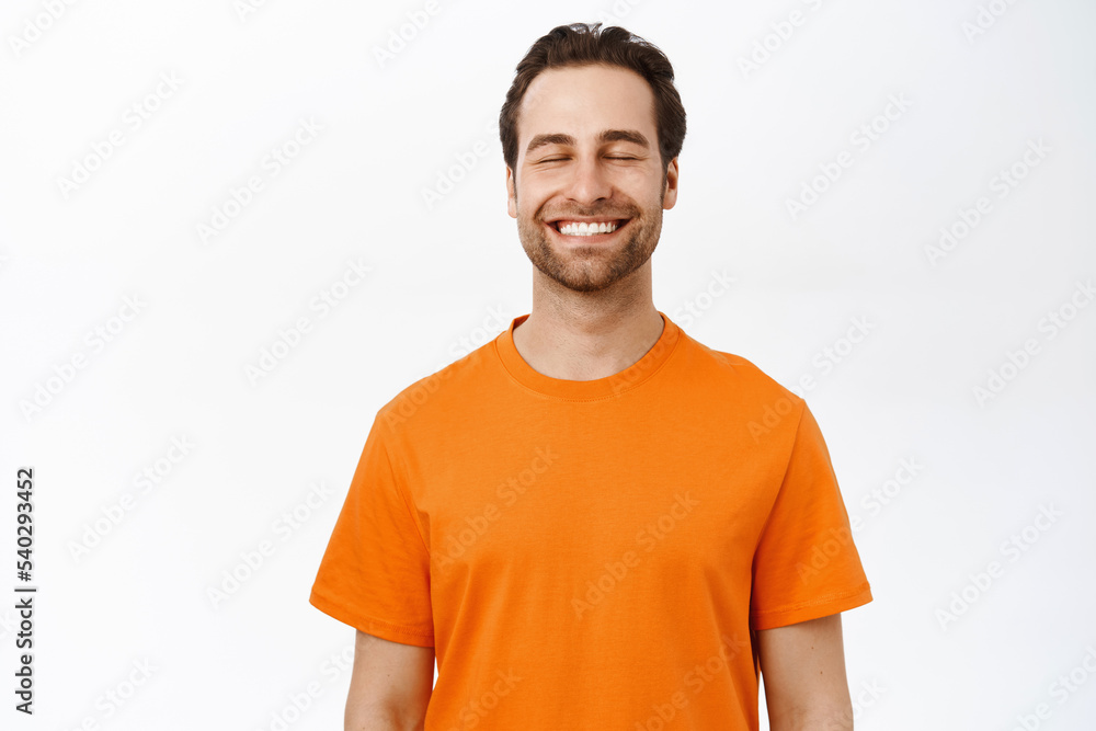 Smiling happy man with closed eyes, dreaming of smth, thinking with pleased carefree face, standing over white background Smiling happy man with closed eyes, dreaming of smth, thinking with pleased carefree face, standing over white background