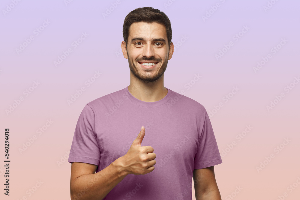 Obraz na plátně Young man showing thumb up with positive emotions and happiness, satisfied with