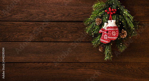 Merry Christmas and Happy New Year  Mittens  fir branches and cones on a wooden background