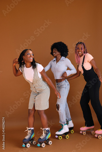 Studio portrait of young friend group on rollerskates
 photo