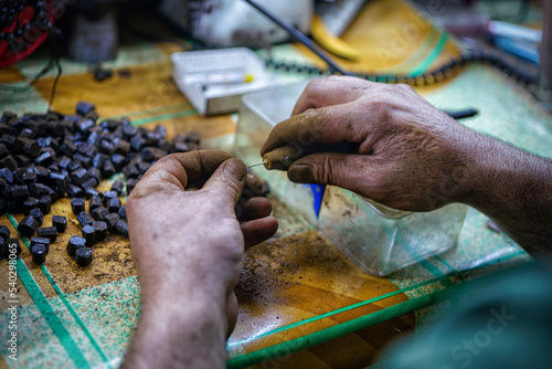 a worker making a rosary with her hands and her hands