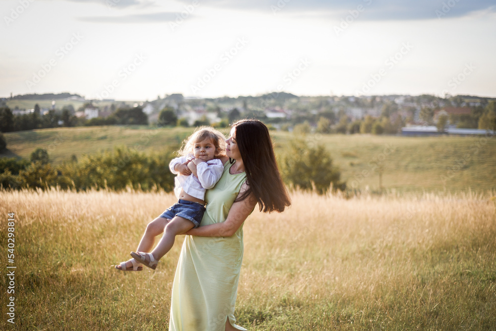 mother plays with her child in the evening park