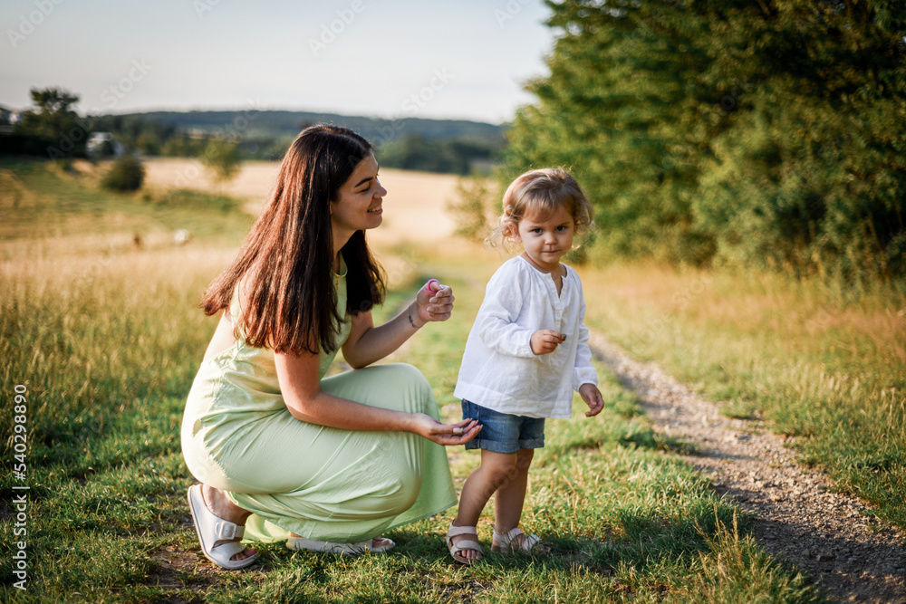 mother plays with her child in the evening park mother plays with her child in the evening park