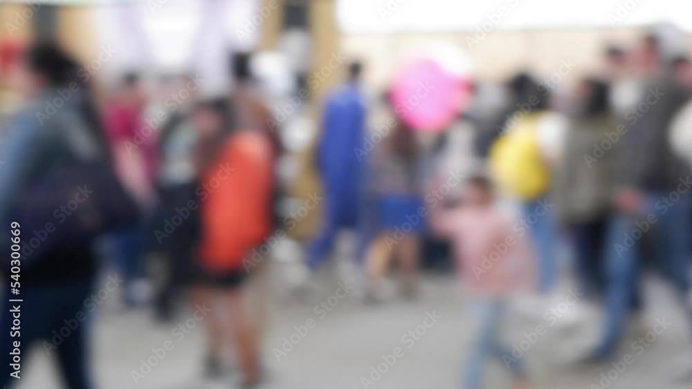 Panning defocused video of many people walking at a fair from a front view Panning defocused video of many people walking at a fair from a front view