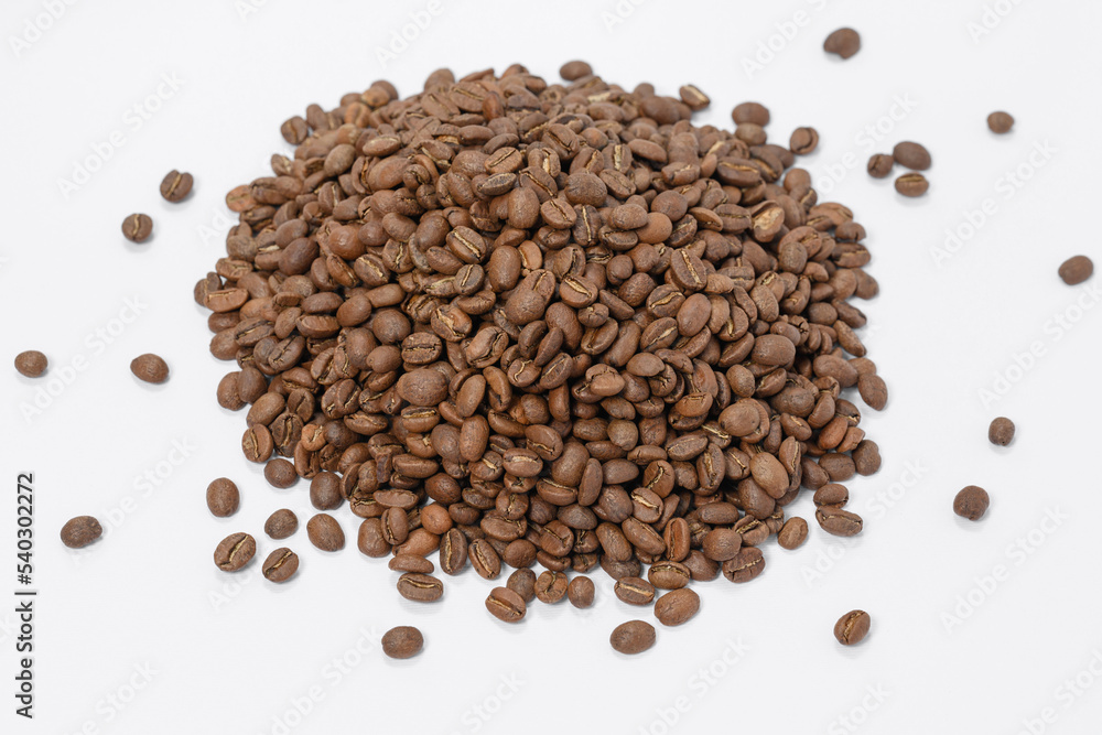 A pile of coffee beans on a white background, place for advertising. A pile of coffee beans on a white background, place for advertising.