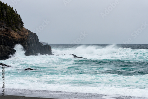 An angry turquoise green color massive rip curl of a wave as it barrels rolls along the ocean. The white mist and froth from the wave are foamy and fluffy. The ocean in the background is deep blue.  © Dolores  Harvey