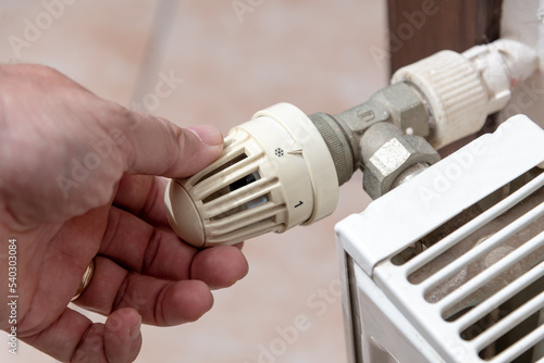 The hand that closes the radiator valve of the boiler in Europe, where there is a shortage of natural gas due to the Russian war