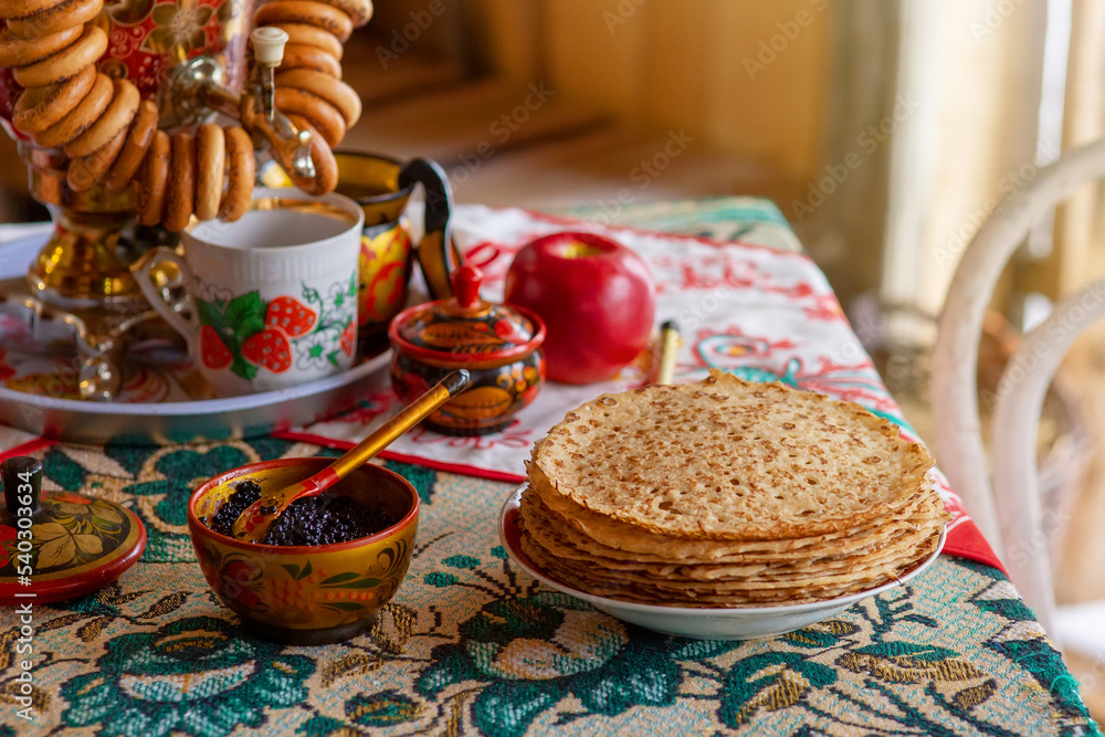 Traditional Russian food,pancakes with caviar, stand on the table with a samovar