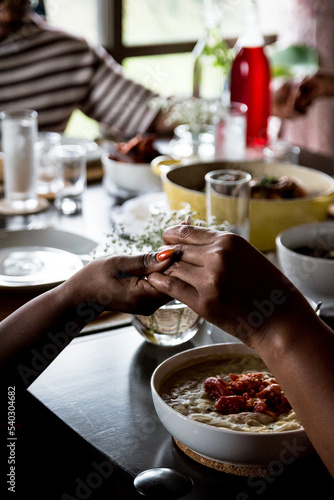 Close-up of Two African American women holding hands to pray before Sunday Dinner, Soul Food, copy space