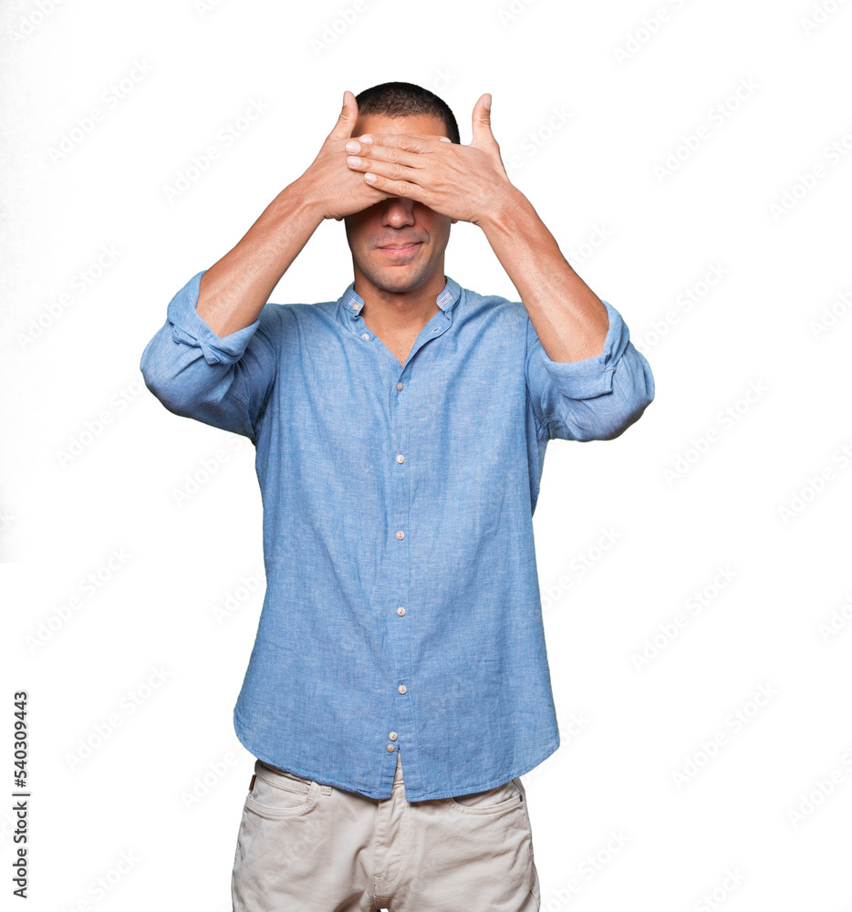 Young man covering his eyes with his hands Young man covering his eyes with his hands