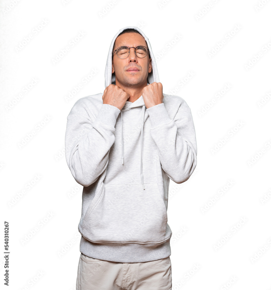 Concerned young man making a gesture of being cold Concerned young man making a gesture of being cold