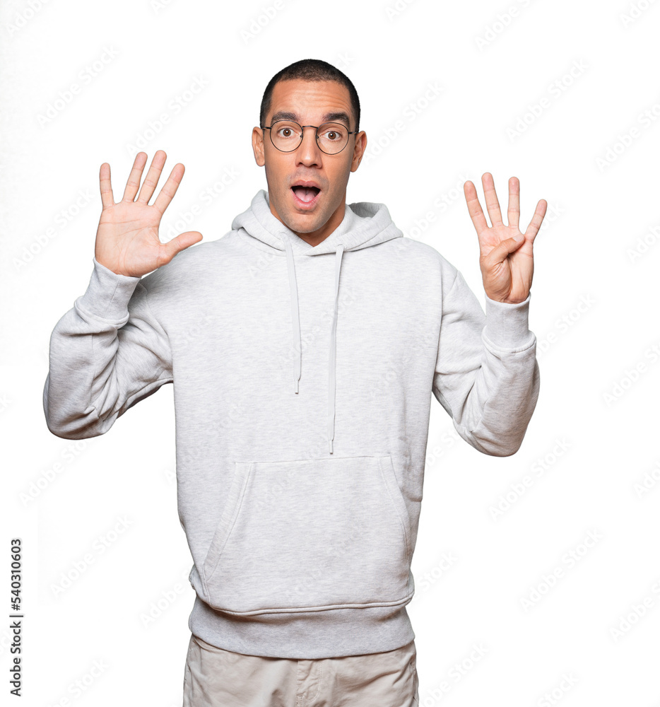 Happy young man doing a number nine gesture with his hands Happy young man doing a number nine gesture with his hands