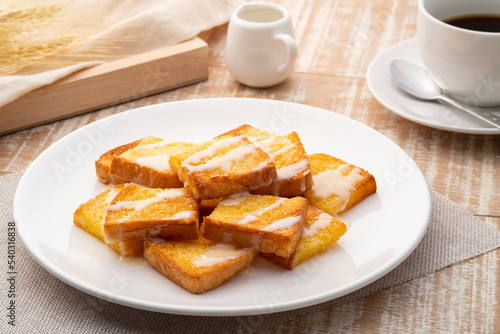 Sliced Air fryer grilled butter toast,golden brown crispy bread topped with sugar and sweetened condensed milk on white plate