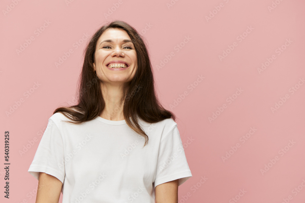 a beautiful, happy, emotional woman is standing in a light cotton T-shirt and raising her head up smiling broadly a beautiful, happy, emotional woman is standing in a light cotton T-shirt and raising her head up smiling broadly