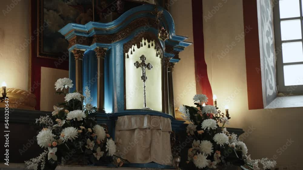 Silver cross with crucifixion stands in illuminated altar of church. Silver cross with crucifixion stands in illuminated altar of church.