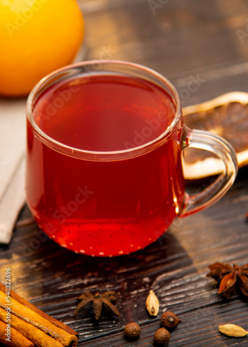 A mug of fruity red tea on a wooden background.