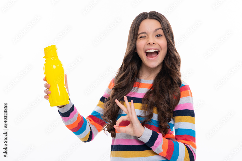 Teen girl with water from plastic bottle on isolated background, copy space. Kid girl care body hydration. Active leisure and water balance. Excited face, cheerful emotions of teenager girl. Teen girl with water from plastic bottle on isolated background, copy space. Kid girl care body hydration. Active leisure and water balance. Excited face, cheerful emotions of teenager girl.