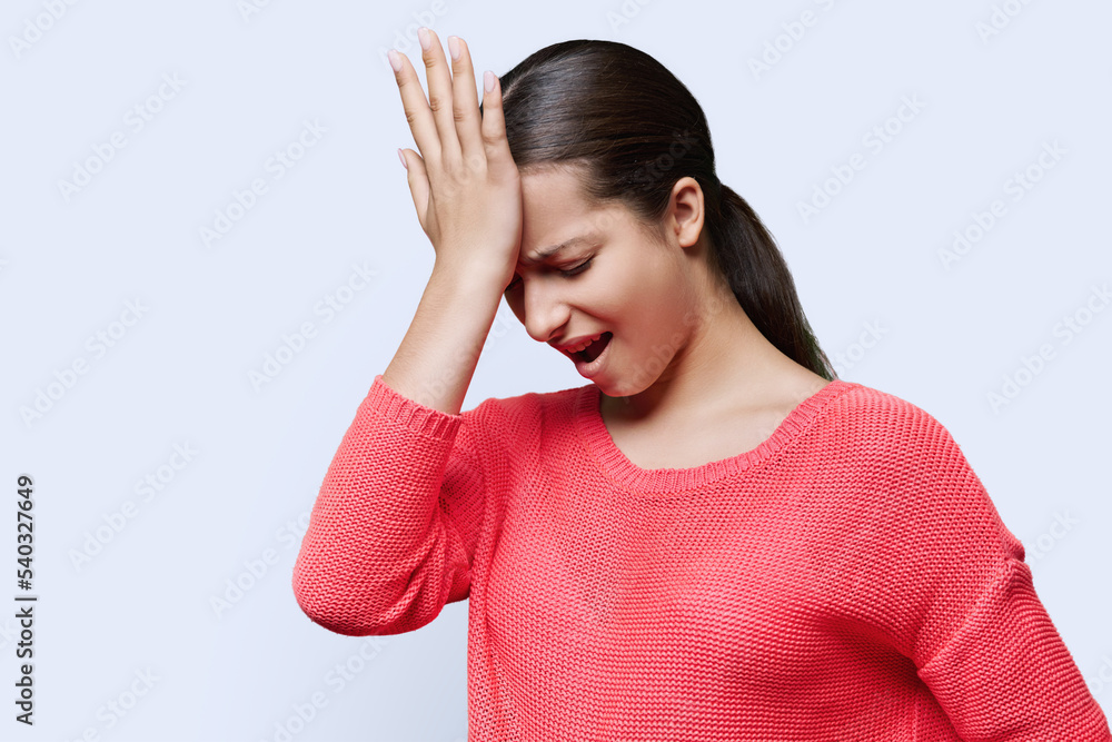 Confused female holding hand on forehead, distressed grimace on face Confused female holding hand on forehead, distressed grimace on face