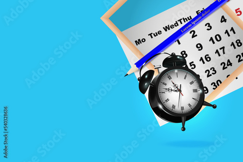 Close up of calendar and alarm clock on blue background, business meeting planning or trip planning concept.