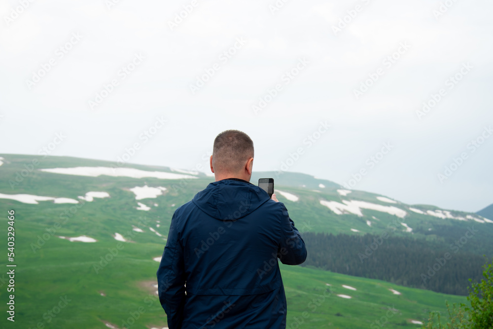 A man in the mountains with a phone. Vacation.