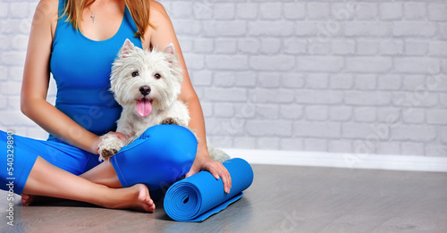 Wide picture of a yoga girl sitting on the floor with her dog