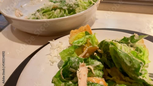 Panning Close Up Of Chicken Caesar Salad In Restaurant Overlooking Kitchen
