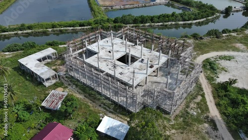 aerial view of building under construction shows the structure of concrete columns and decks and steel frames.