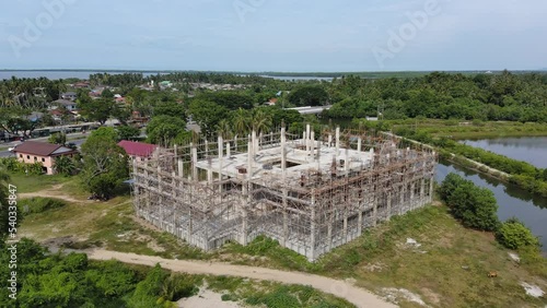 aerial view of building under construction shows the structure of concrete columns and decks and steel frames.