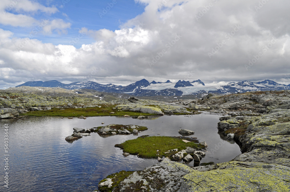 Sognefjell, Jotunheim, Norway - rocky landscape with snow in a natural park. Snow-covered rocks, mountains and icy lakes.