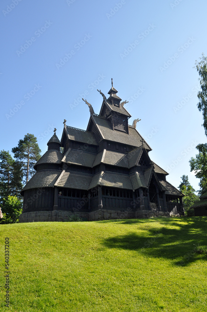 Oslo, Norway - Old memorial wooden church on Bygdoy peninsula and green meadow