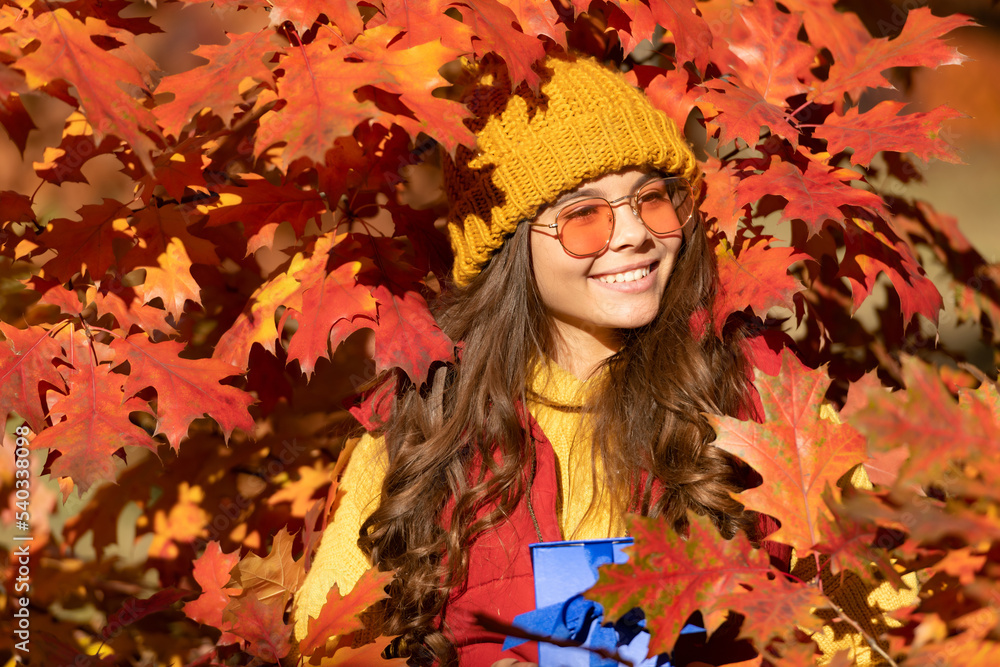 happy child with present box on autumn leaves background happy child with present box on autumn leaves background