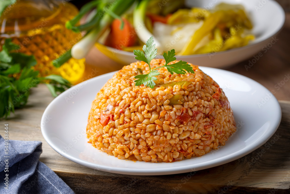Traditional turkish bulgur pilaf with tomato sause in plate (Turkish name; meyhane pilavi)