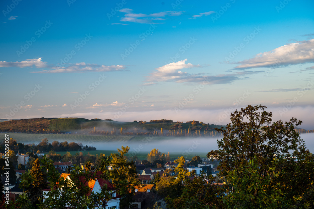 Obraz premium a large valley with a city and incoming fog