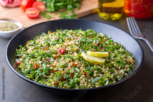 Traditional Lebanese salad tabouli tabule with quinoa, herbs, tomatoes, mint and lemon.