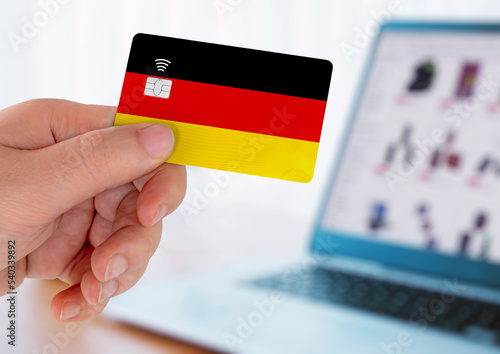 Hands holding plastic credit card and using laptop. Online shopping concept in Germany