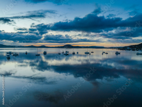 Aerial sunrise waterscape with boats  rain clouds and reflections