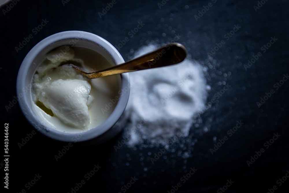 Yaourt nature dans pot blanc avec sucre en poudre Yaourt nature dans pot blanc avec sucre en poudre