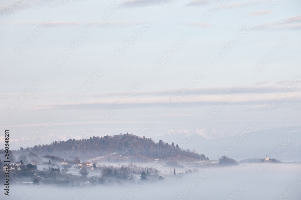 Winter alpine view with town in clouds